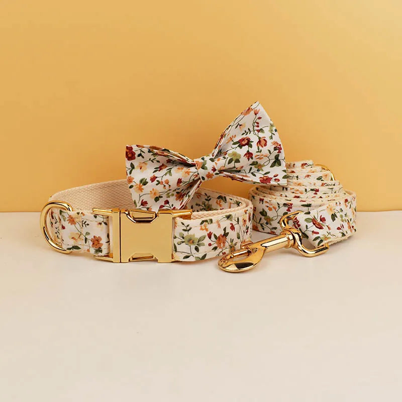 Floral dog collar, bow tie, and leash set on a beige surface with a yellow background