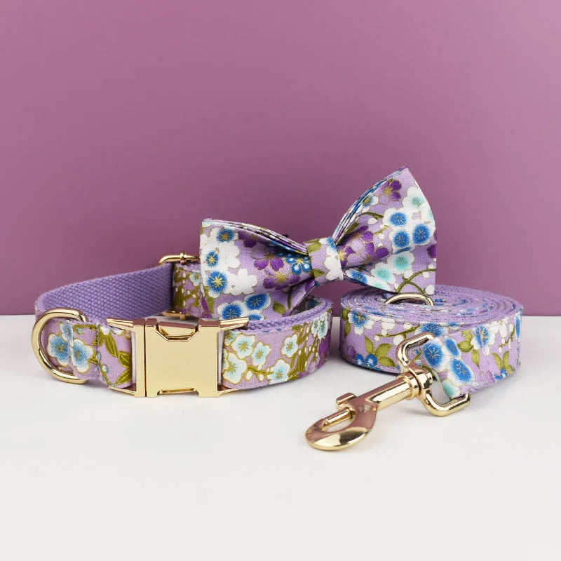 Floral dog collar, bow tie, and leash set on a white surface with a purple background