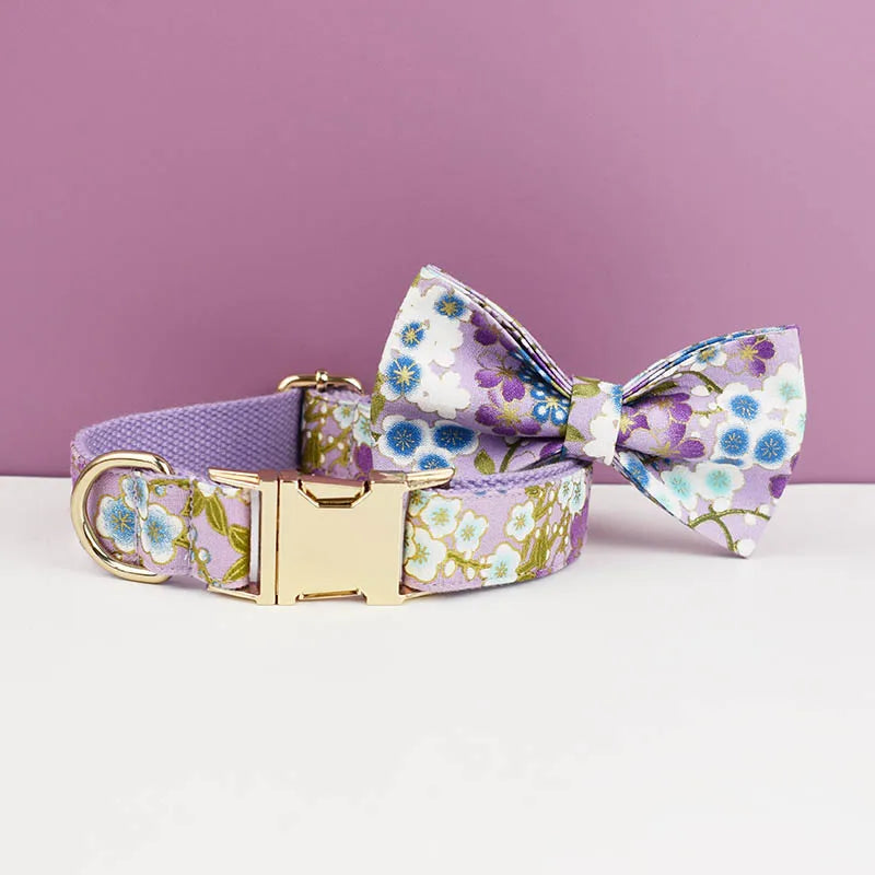 Floral dog collar and bow tie set on a white surface with a purple background