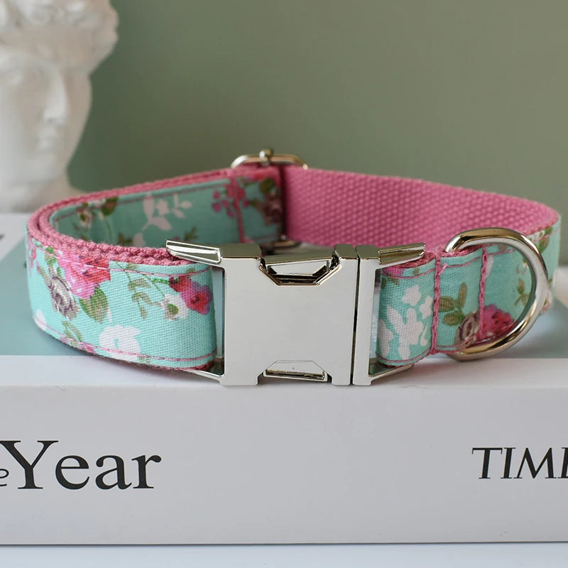 Floral-patterned dog collar with a pink internal strap on a white surface.