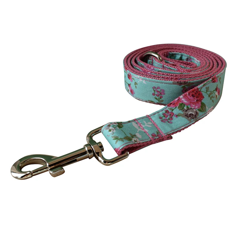 Floral patterned dog leash with a metal clip on a white background