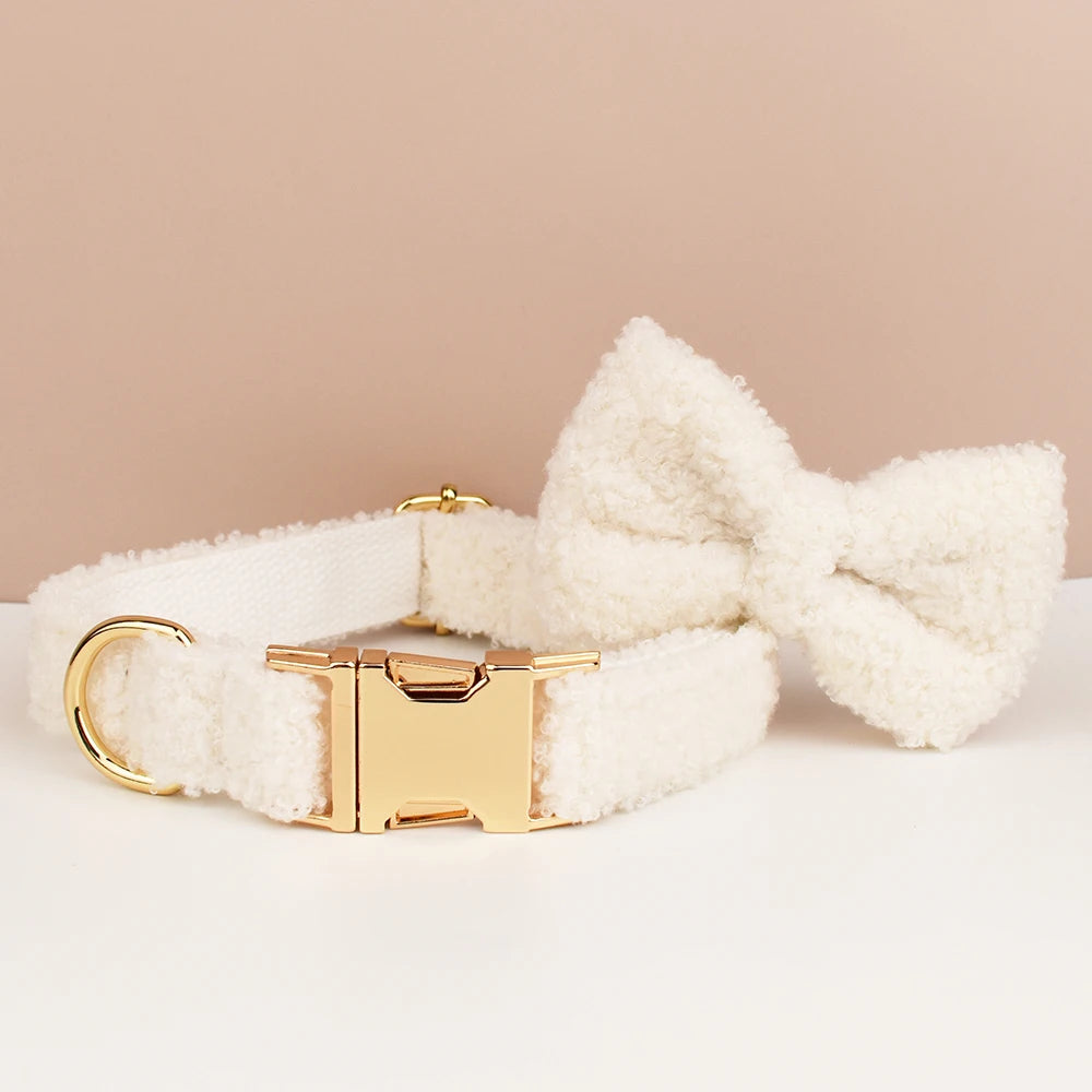 White fluffy dog collar with a gold clasp on a beige background