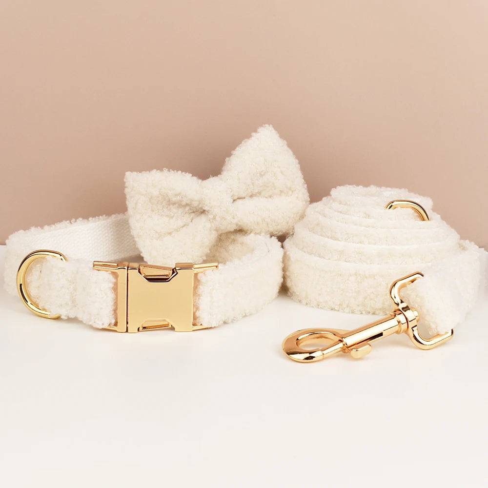 White fluffy dog collar and leash set with gold hardware on a beige background