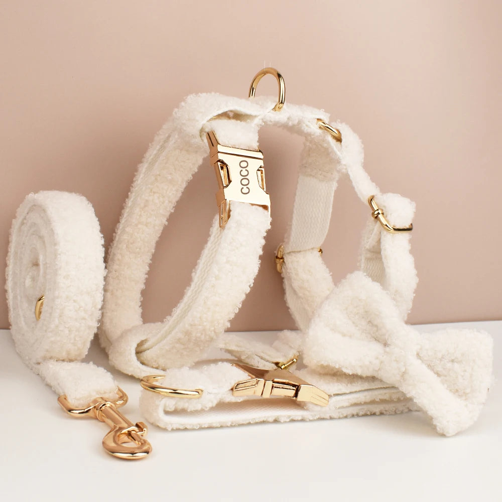 White dog harness with gold hardware on a beige background