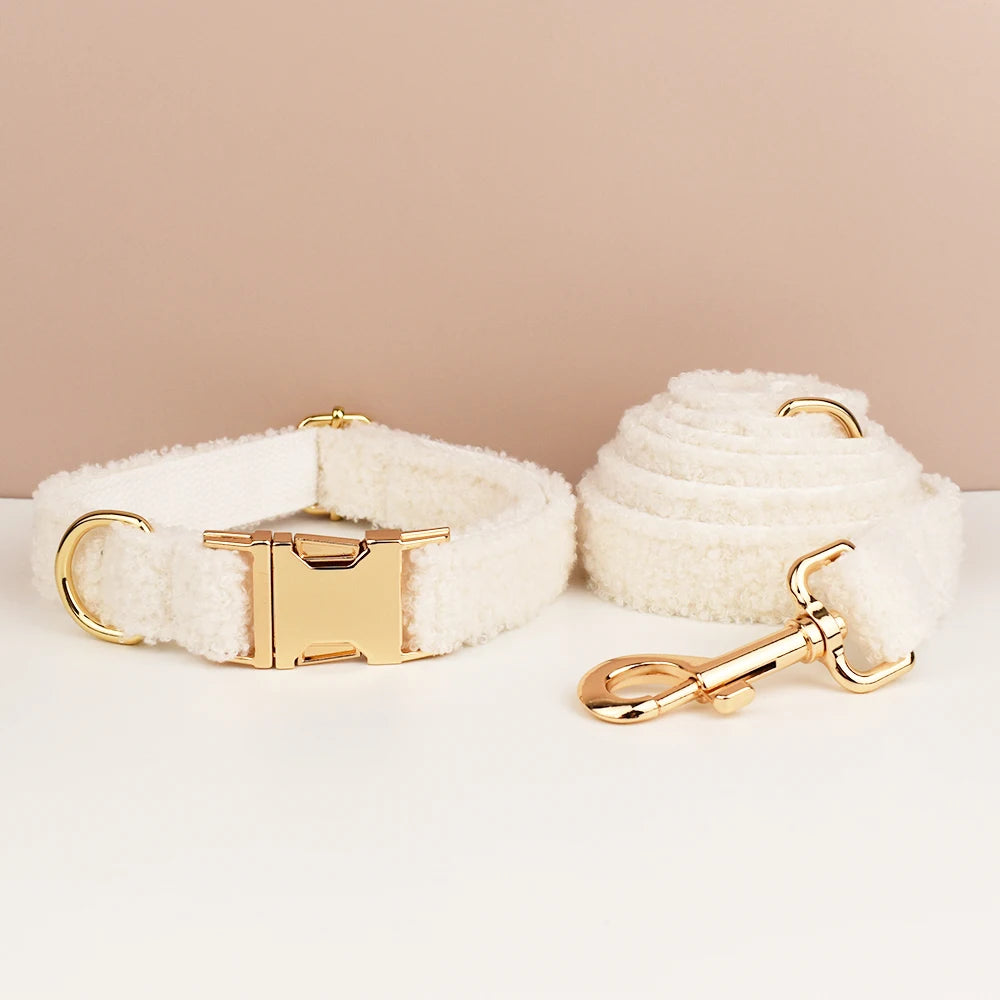 White dog collar and leash set with gold hardware on a beige background