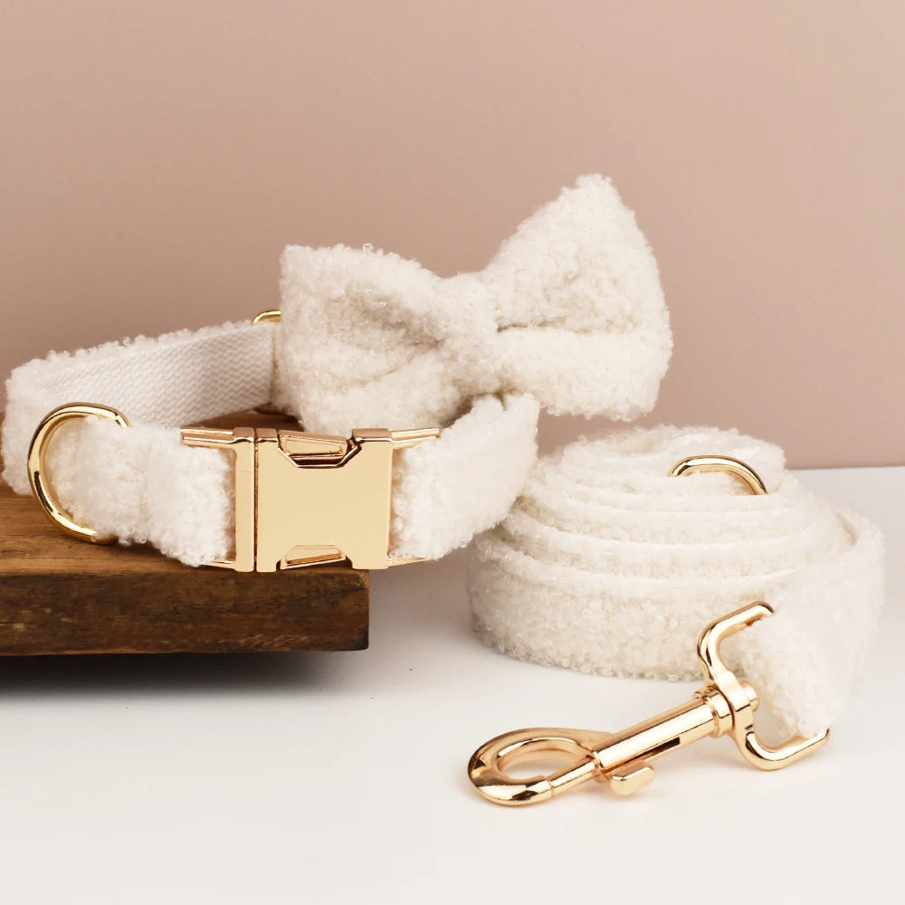 White fleece dog collar and leash set with gold hardware on a beige background