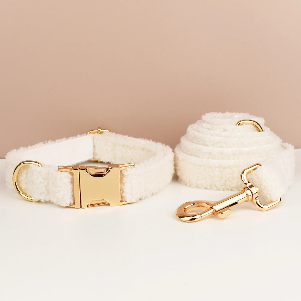 White fluffy dog collar and leash set with gold hardware on a beige background