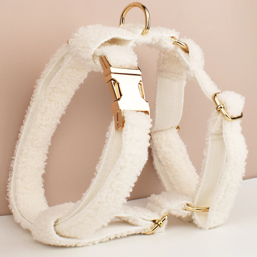 White fluffy dog harness with gold hardware on a beige background