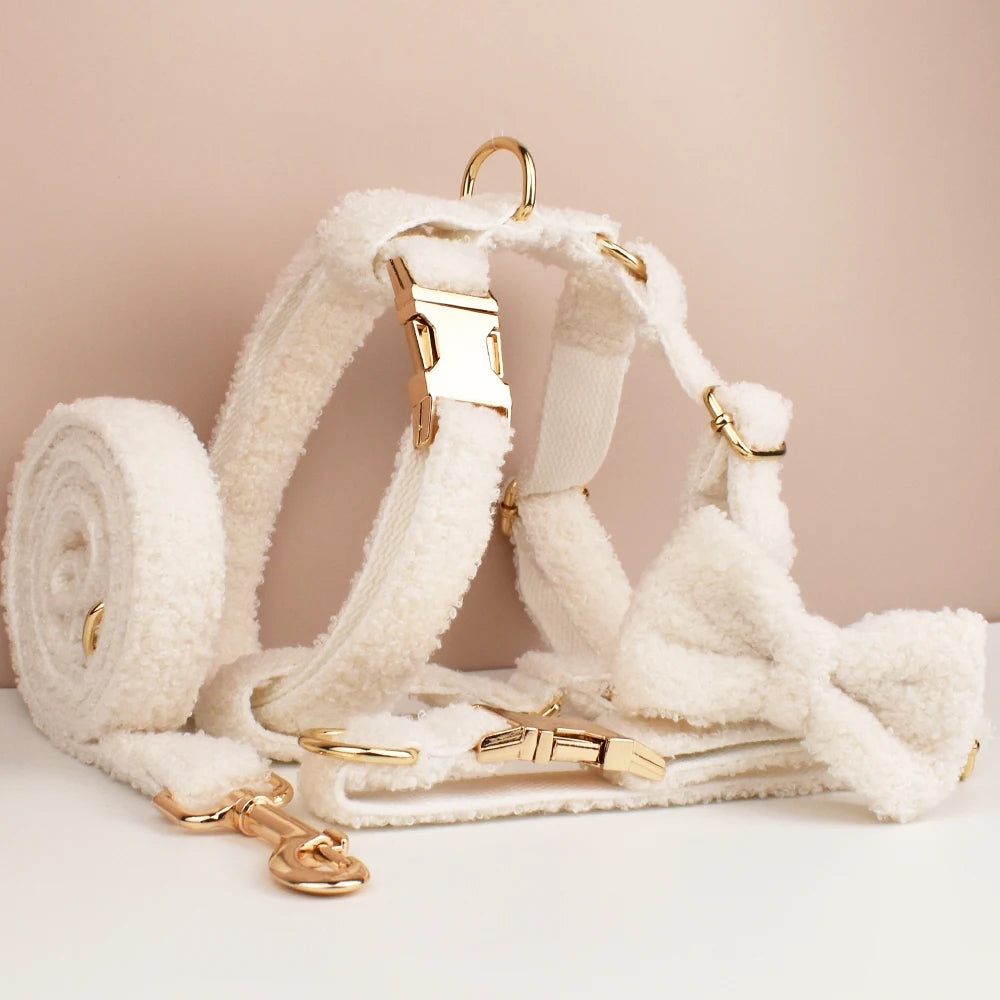 White dog harness with gold hardware on a beige background