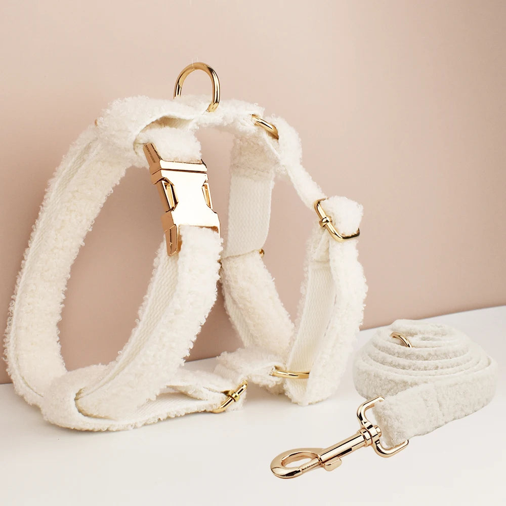 White dog harness and leash set with gold hardware on a beige background