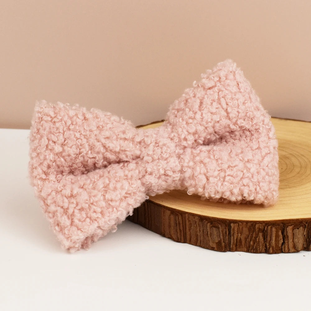 Pink textured dog bow on a wooden stand with a beige background