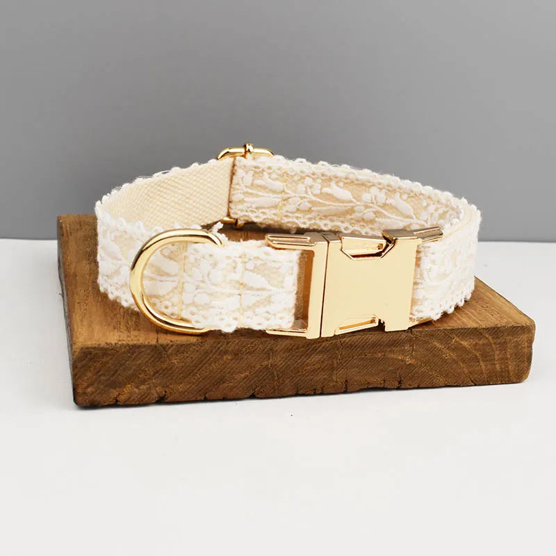 White lace dog collar with gold hardware on a wooden stand against a gray background