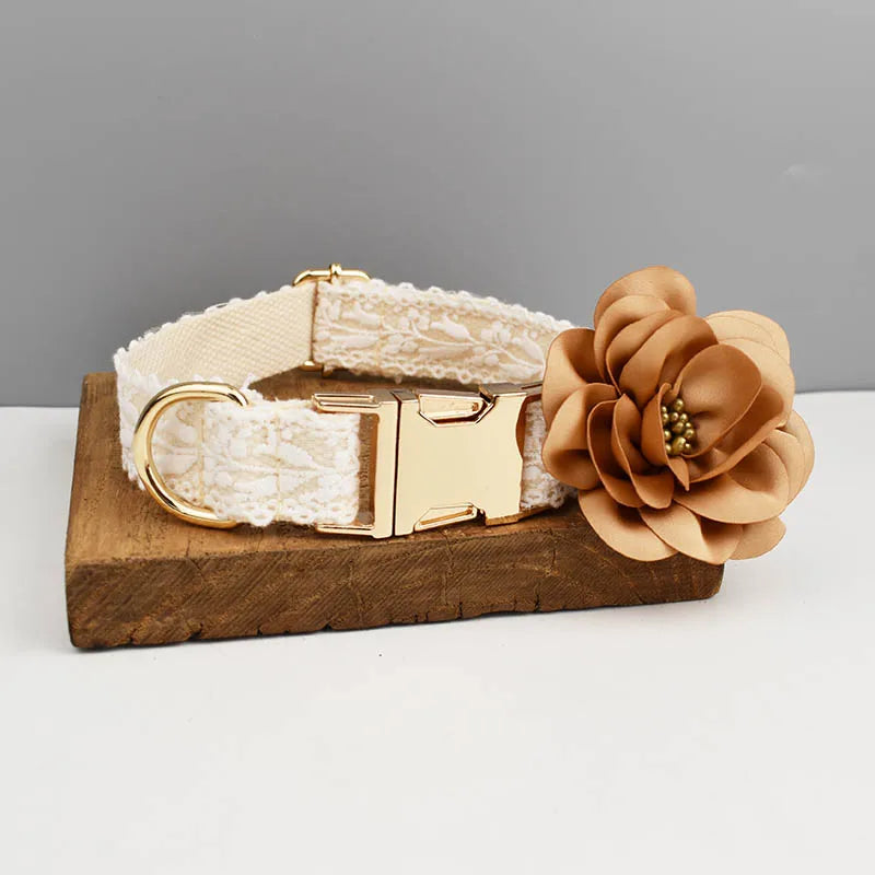 Dog collar with lace detailing and a large brown flower on a wooden stand against a gray background.