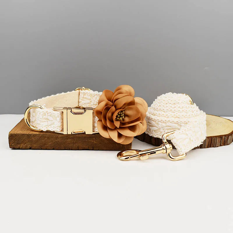 Two dog collars with floral attachments on a wooden block against a gray background