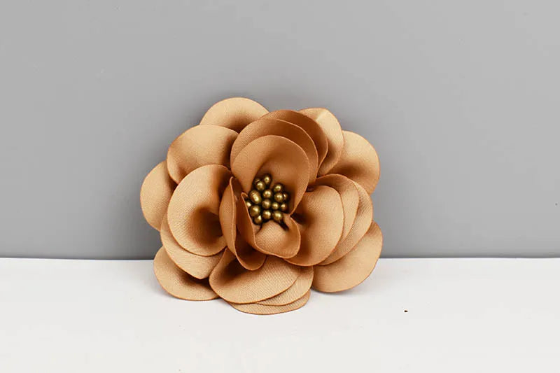 Brown flower-shaped object on a white surface with a gray background