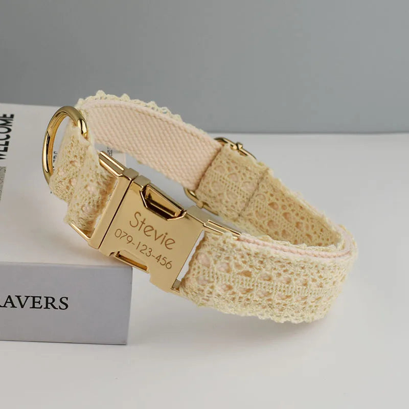 Beige lace dog collar with gold buckle and engraved nameplate on a gray background