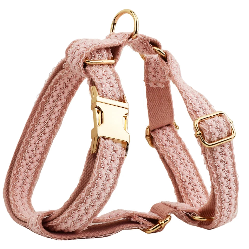 Pink textured dog harness with gold hardware on a white background
