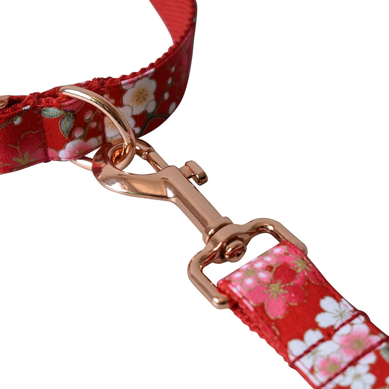 Red floral dog leash with a rose gold clasp on a white background