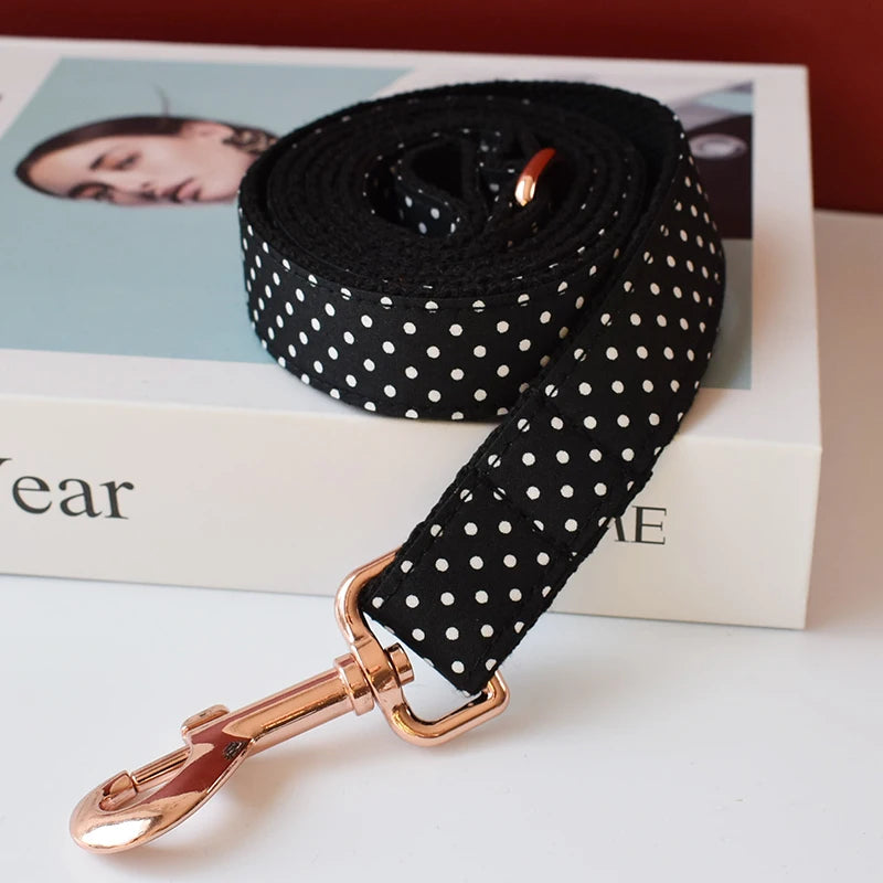 Black polka dot dog leash with rose gold clip on a magazine