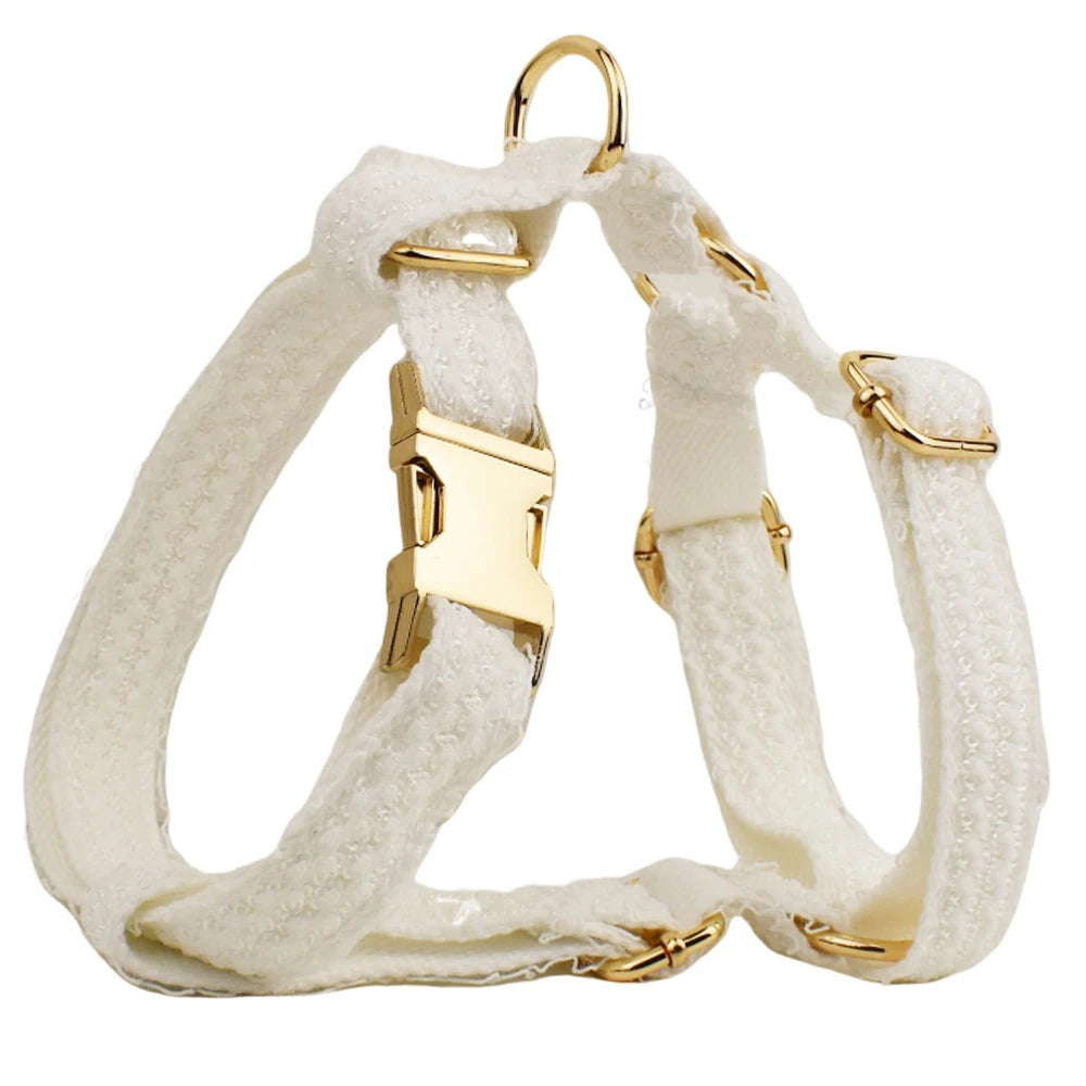 White dog harness with gold hardware on a white background