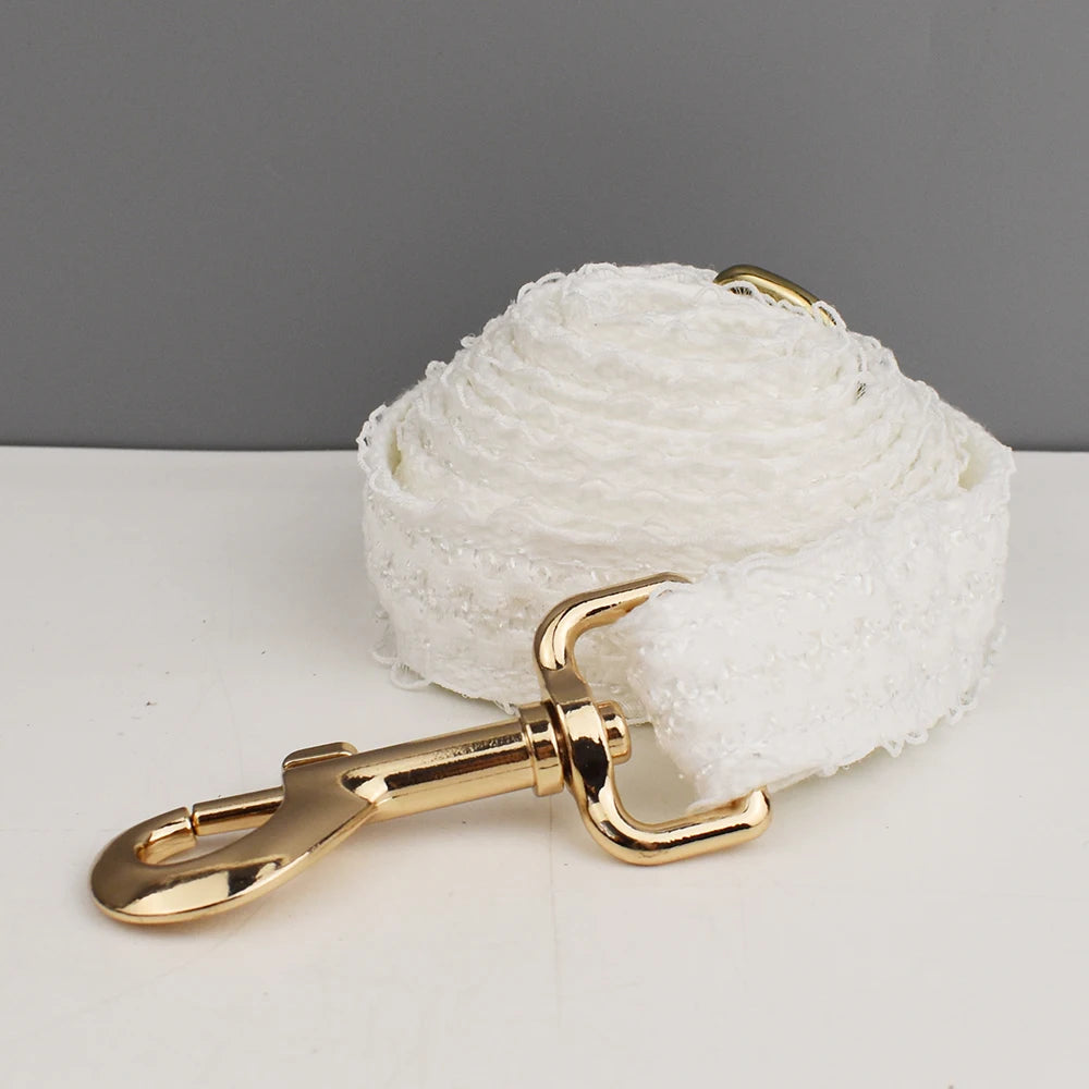 White dog leash with gold clasp on a gray background
