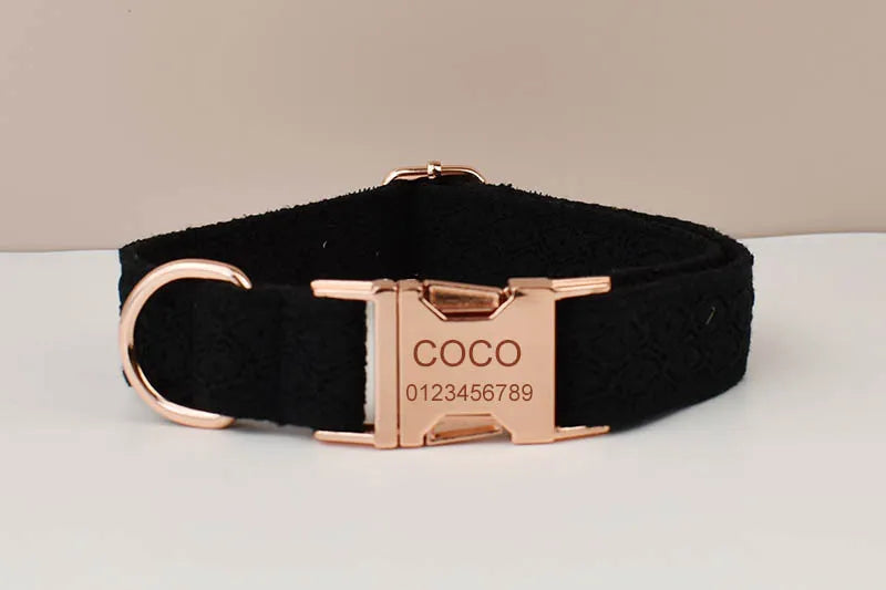 Black dog collar with rose gold buckle and engraved nameplate on a white surface.