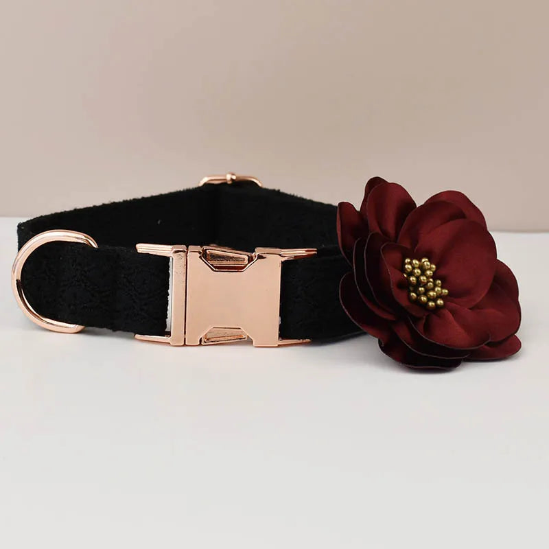 Black dog collar with a rose gold buckle and a burgundy flower accessory on a light gray background