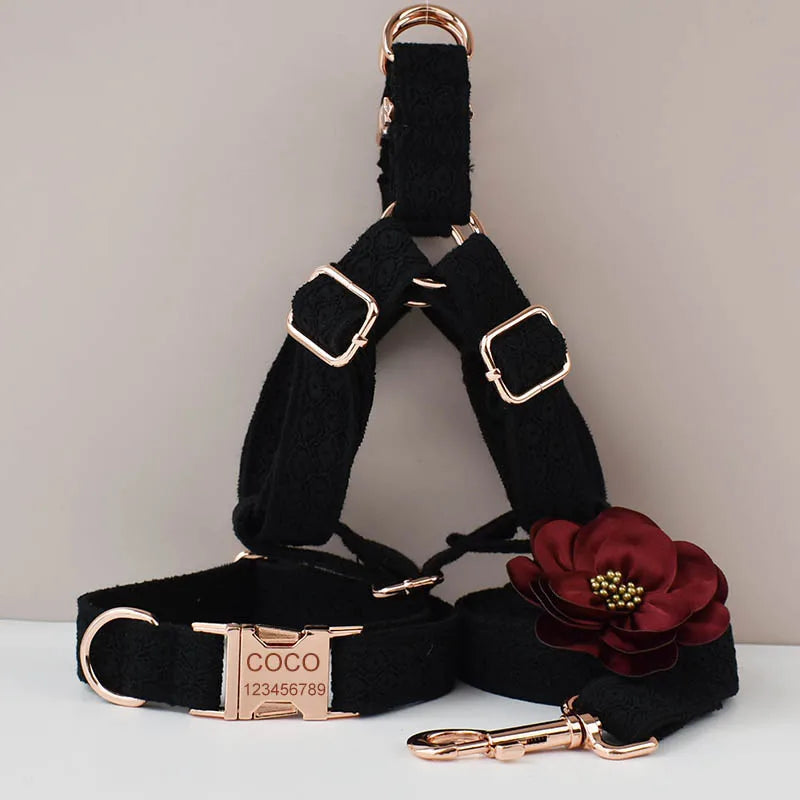 Black dog harness with gold hardware, a red flower accessory, and a COCO branded collar on a light gray background.