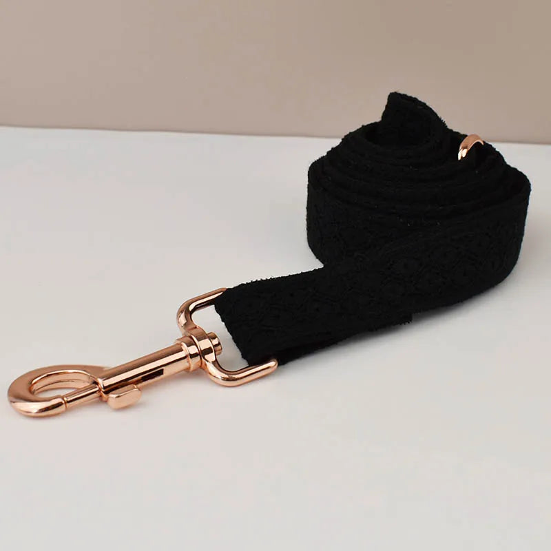 Black dog leash with rose gold clip on a light gray background