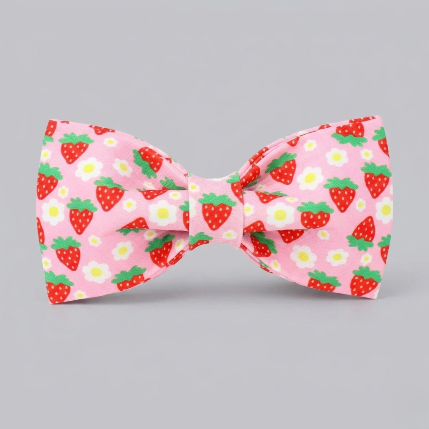 Pink bow tie with strawberry pattern on a gray background