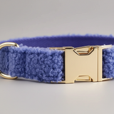 Blue textured dog collar with a gold buckle on a gray background