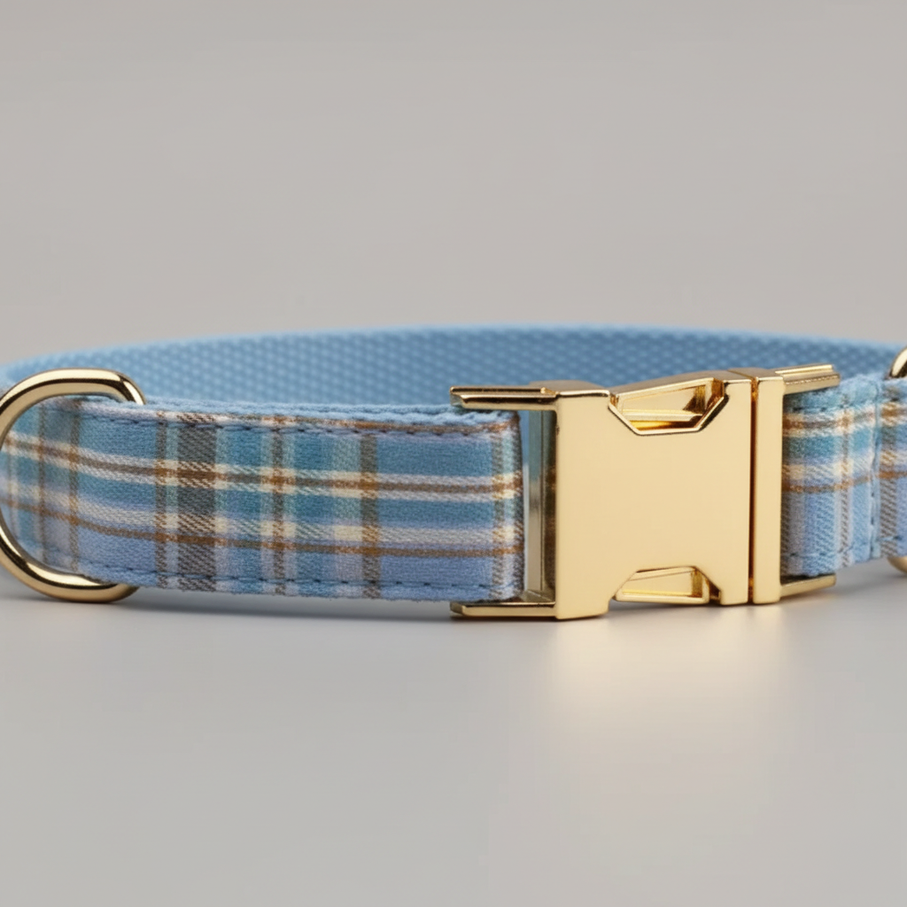 Dog collar with blue plaid pattern and gold buckle on a gray background