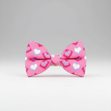 Pink bow tie with heart pattern on a gray background