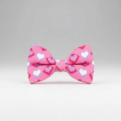 Pink bow tie with heart pattern on a gray background
