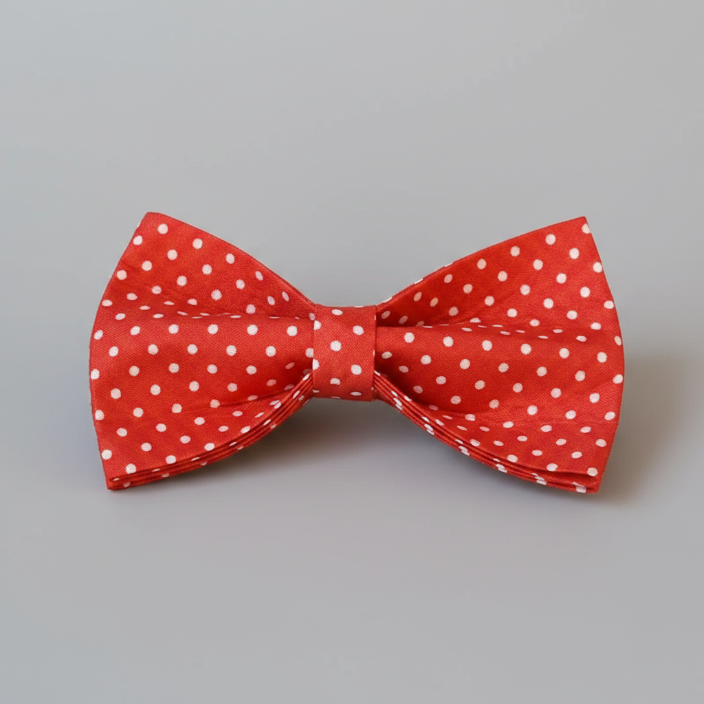 Red bow tie with white polka dots on a gray background