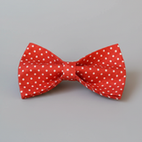Red bow tie with white polka dots on a gray background