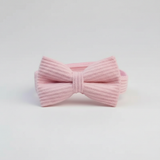 Pink knitted bow tie on a light gray background