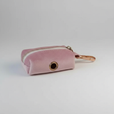Pink velvet keychain pouch with gold zipper and clasp on a light gray background