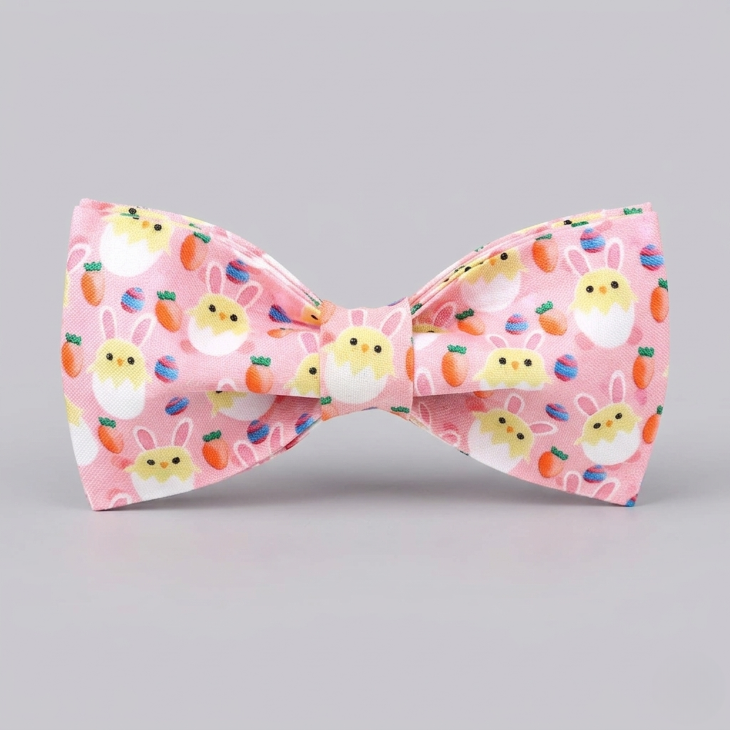 Pink bow tie with Easter-themed design on a gray background
