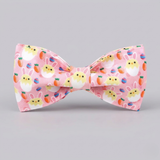 Pink bow tie with Easter-themed design on a gray background