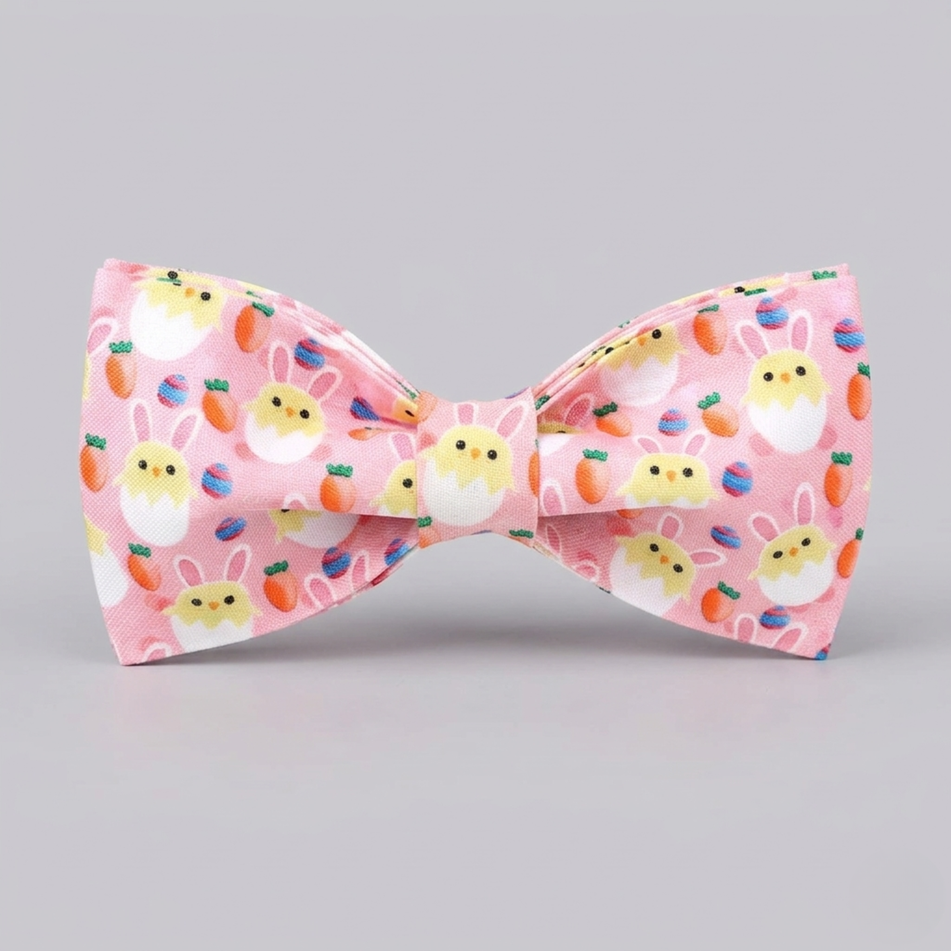 Pink bow tie with Easter-themed design on a gray background