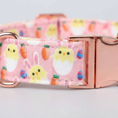 Pink dog collar with Easter-themed design and rose gold buckle on a light gray background