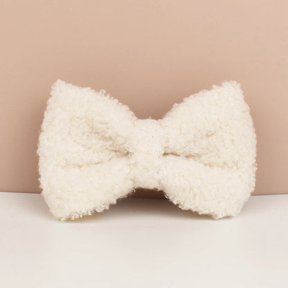 White fluffy bow-shaped pillow on a beige background