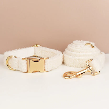 White dog collar and leash set with gold hardware on a beige background