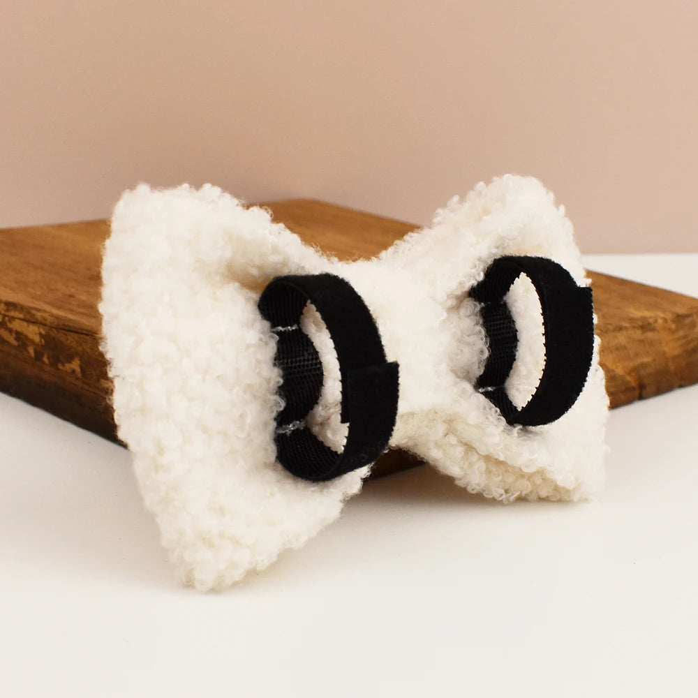 White fuzzy bow-shaped object on a wooden block with a beige background