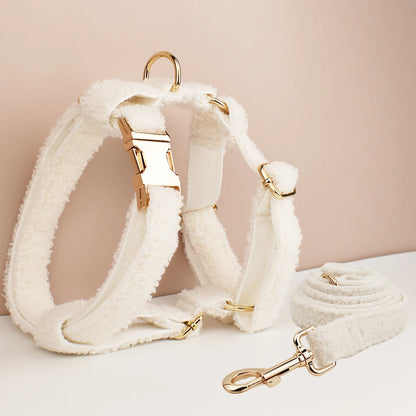 White dog harness and leash set with gold hardware on a beige background