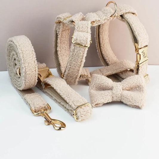Beige pet collar, leash, and bow tie set on a white surface with a neutral background.