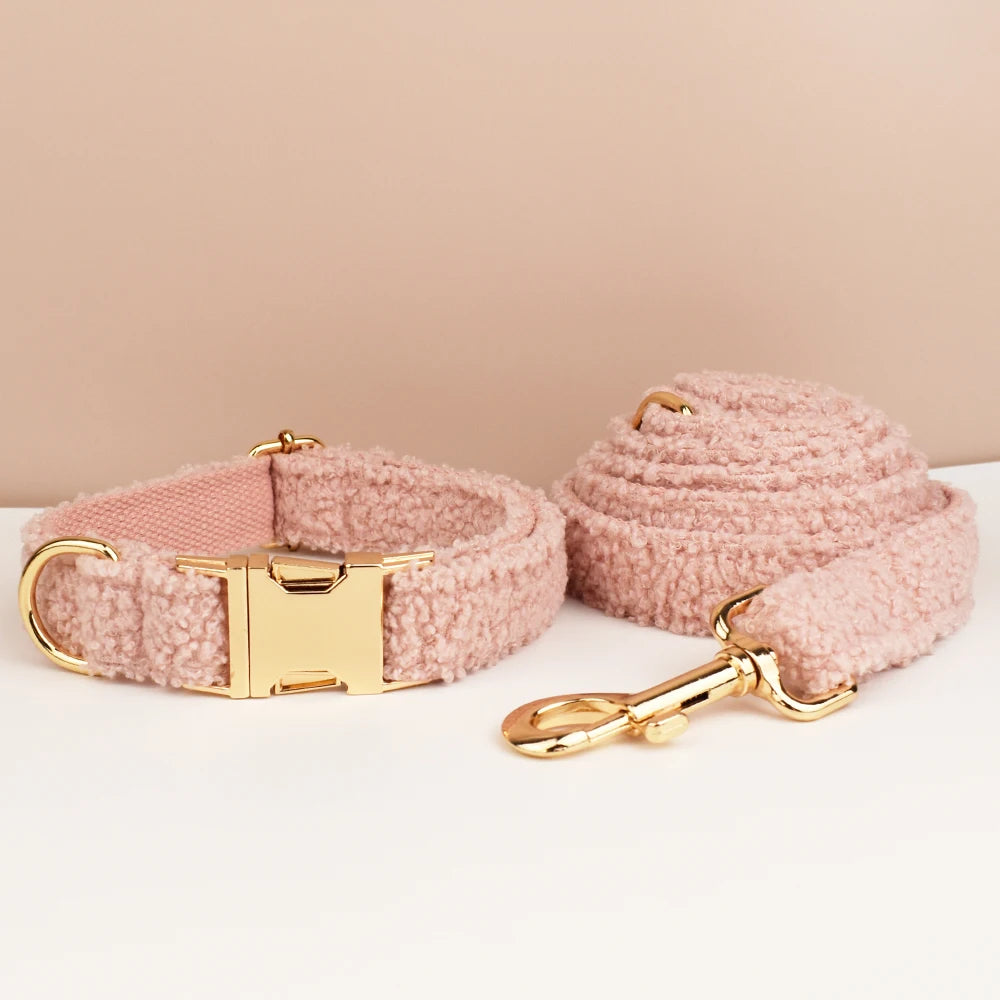 Pink dog collar and leash set with gold hardware on a beige background