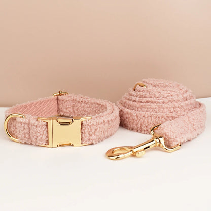 Pink dog collar and leash set with gold hardware on a beige background