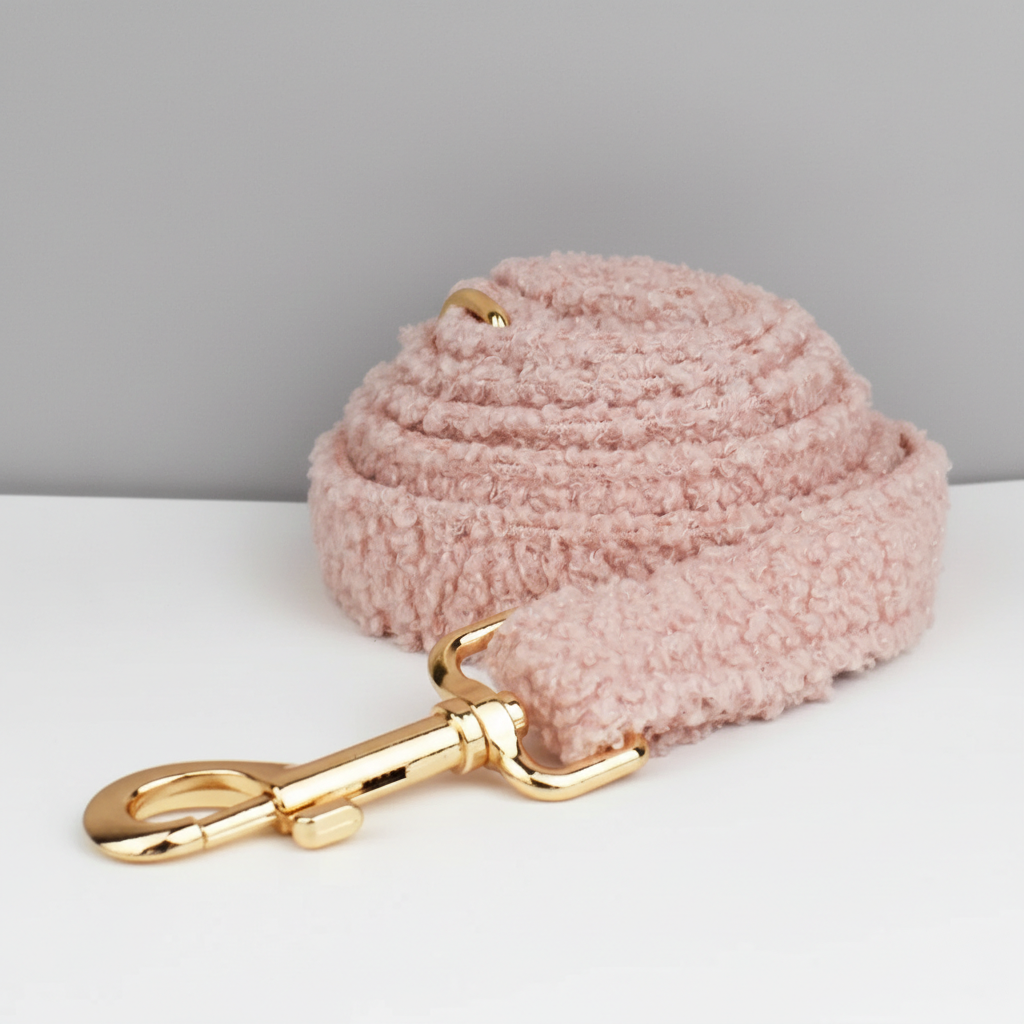 Pink textured dog leash with a gold clasp on a light gray background